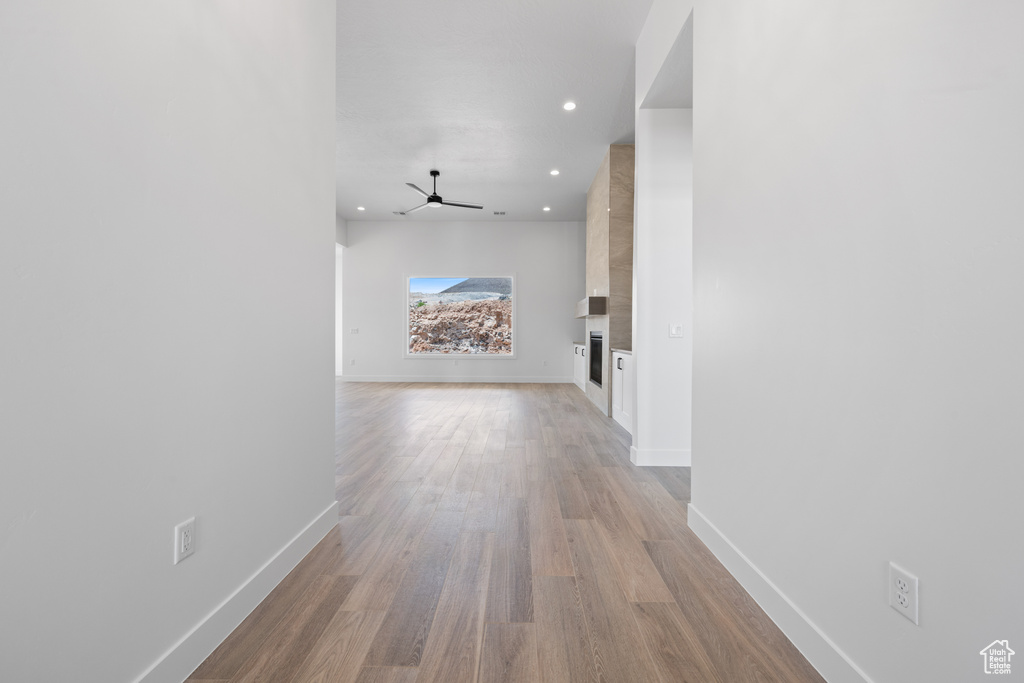 Hall featuring baseboards, light wood-style floors, and recessed lighting