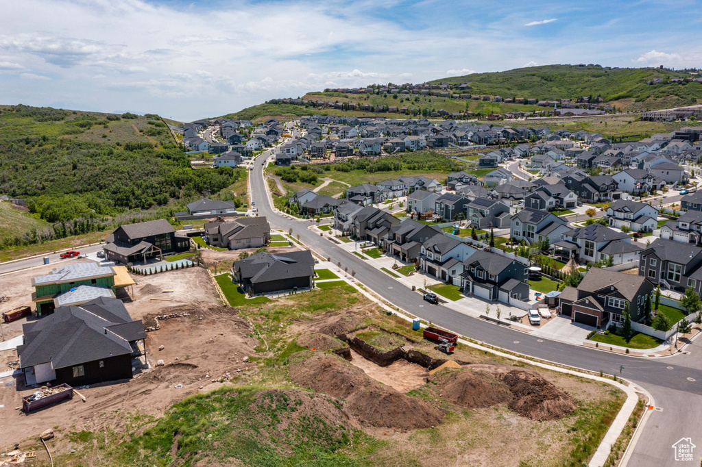 Aerial view of property and surrounding area with nearby suburban area and mountains