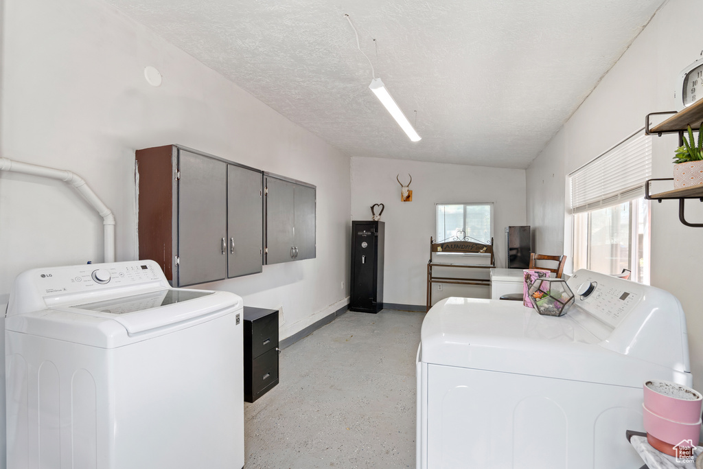 Laundry room with separate washer and dryer, cabinet space, and baseboards