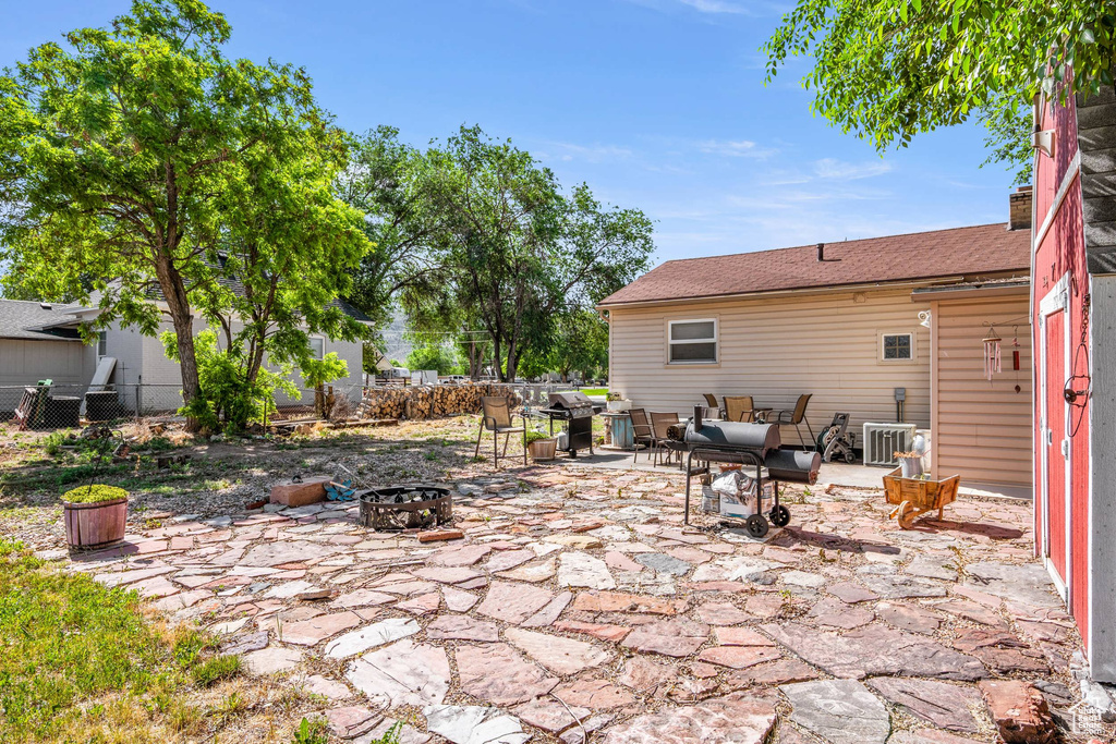 View of patio / terrace with area for grilling, central AC unit, and an outdoor living space with a fire pit