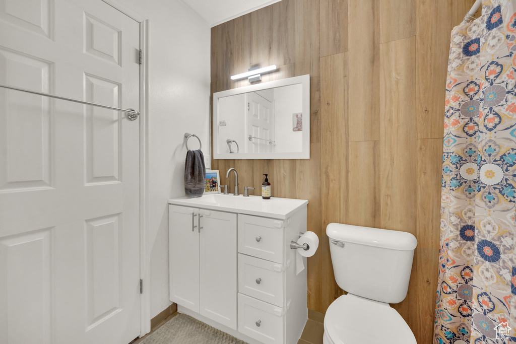 Full bath featuring toilet, vanity, a shower with shower curtain, and baseboards