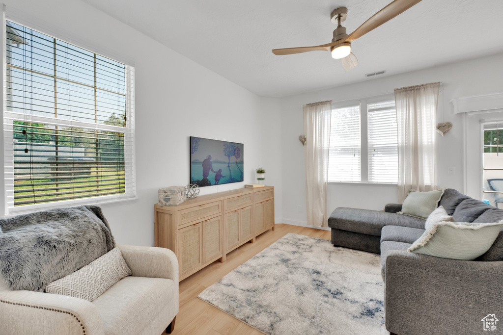 Living area with ceiling fan and light wood finished floors