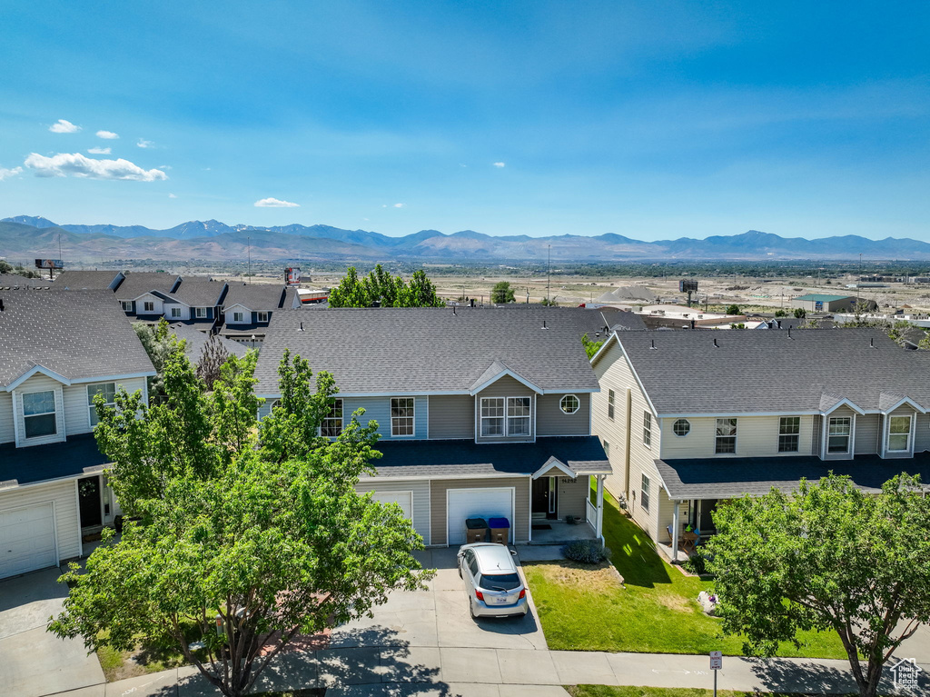 View of front facade with driveway, an attached garage, a mountain view, a residential view, and a shingled roof