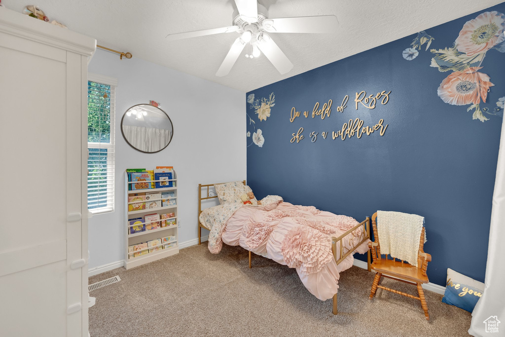 Carpeted bedroom featuring ceiling fan and baseboards