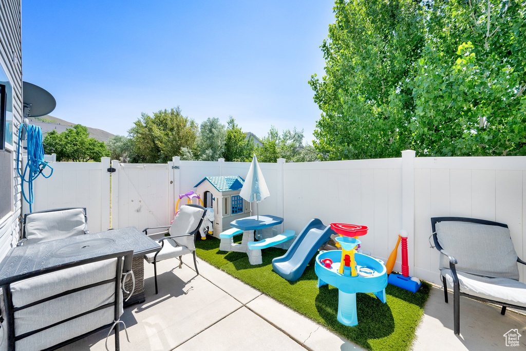 Fenced backyard featuring outdoor dining space, a patio area, and a gate