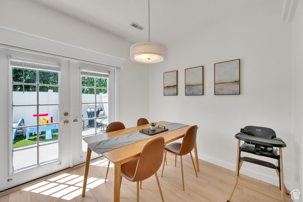 Dining room featuring french doors, light wood-style floors, and baseboards