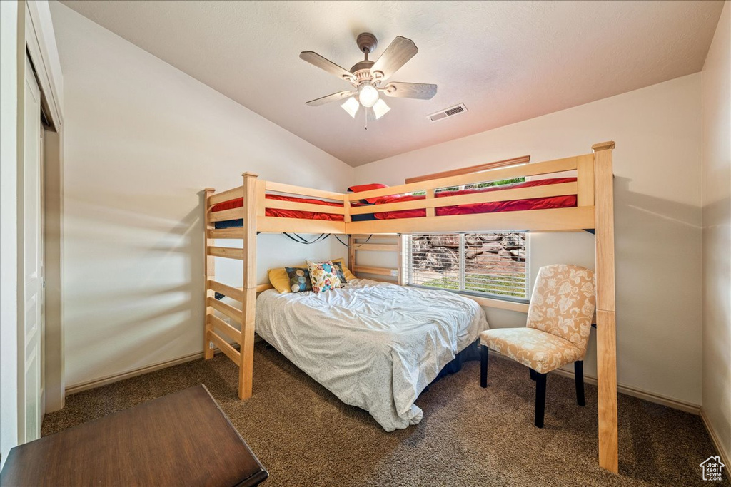 Carpeted bedroom featuring lofted ceiling and ceiling fan