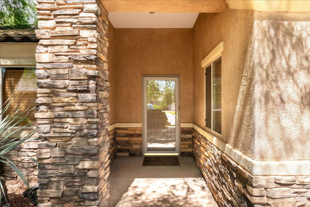 Entrance to property featuring stone siding and stucco siding