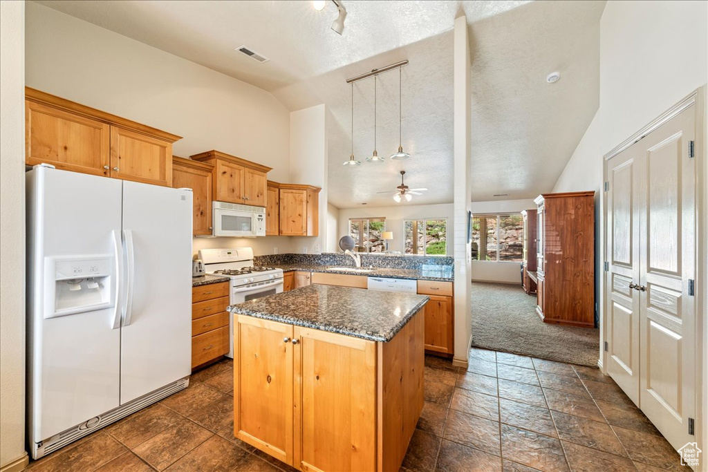 Kitchen with white appliances, a kitchen island, rail lighting, a peninsula, and a ceiling fan