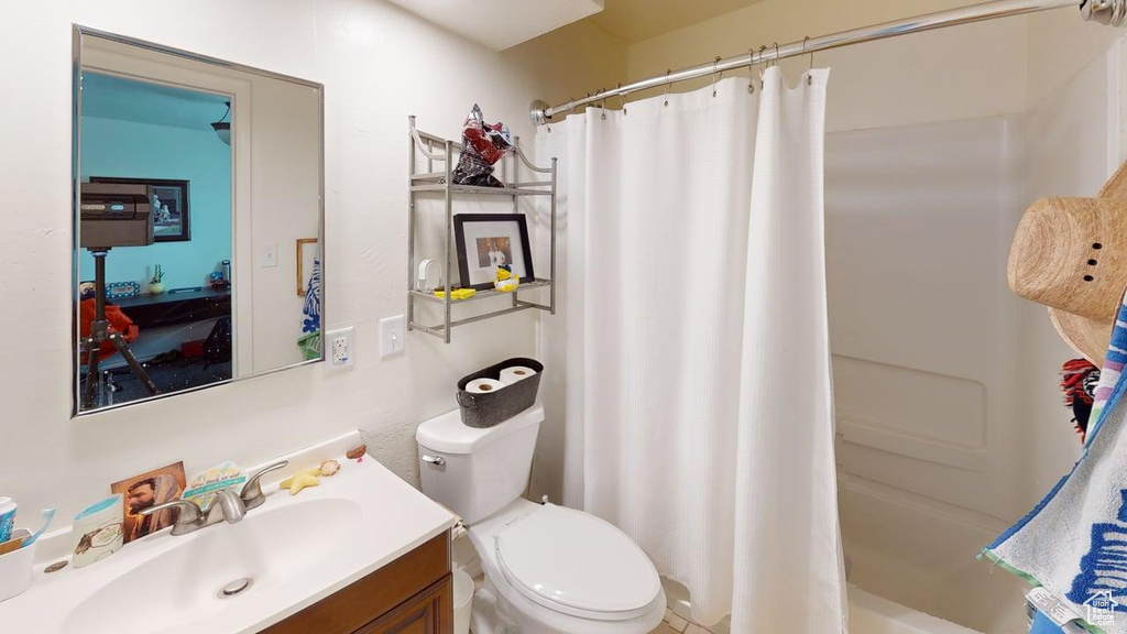 Full bath with vanity, toilet, and shower / bath combo