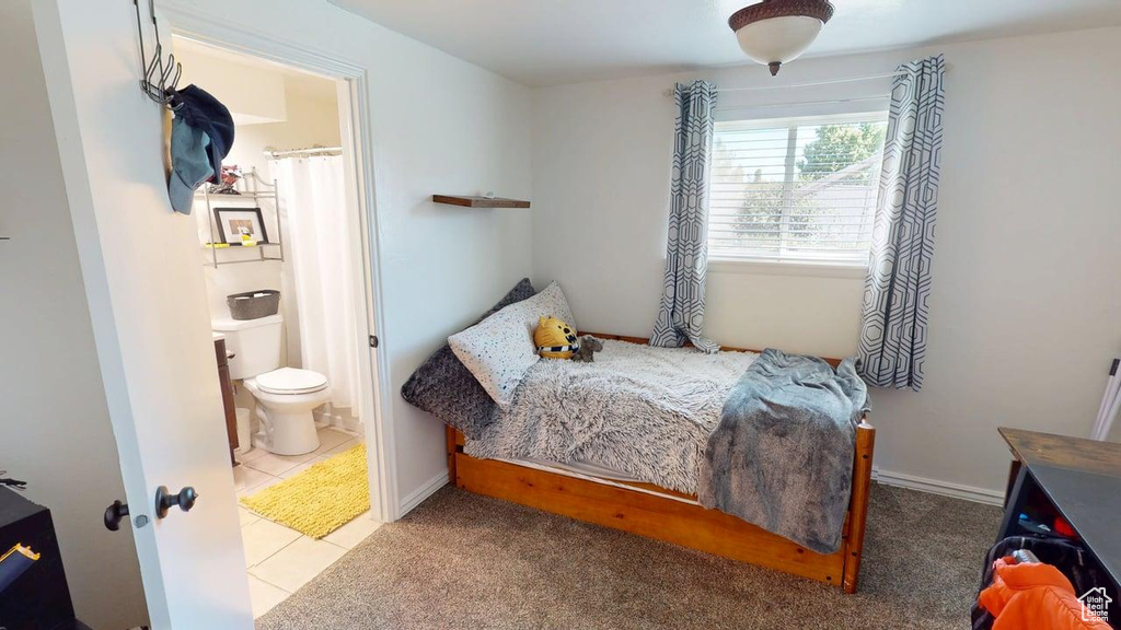 Bedroom featuring ensuite bathroom and tile patterned flooring