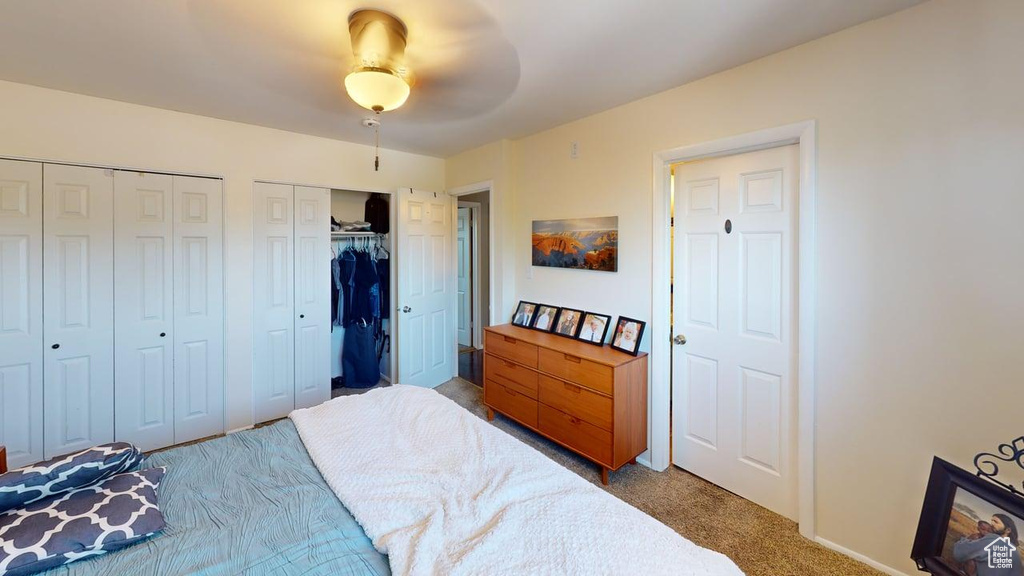 Bedroom featuring multiple closets, carpet, baseboards, and ceiling fan