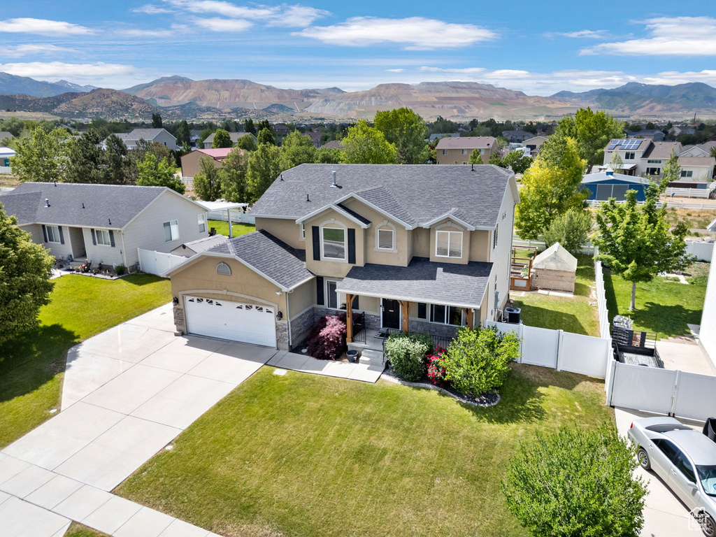 Traditional-style home featuring an attached garage, a residential view, stucco siding, concrete driveway, and roof with shingles