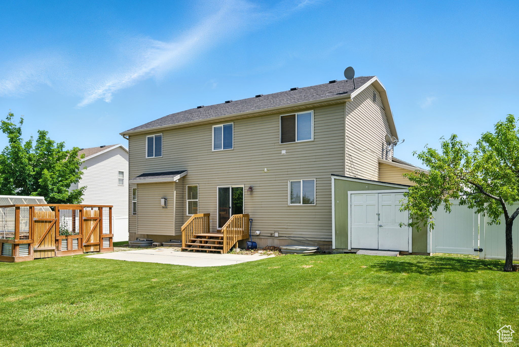 Rear view of property with a patio area, a lawn, and an outbuilding
