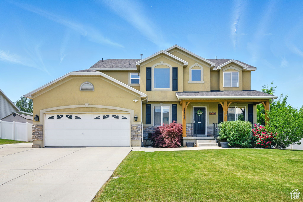 View of front of property with stucco siding, concrete driveway, stone siding, and a garage