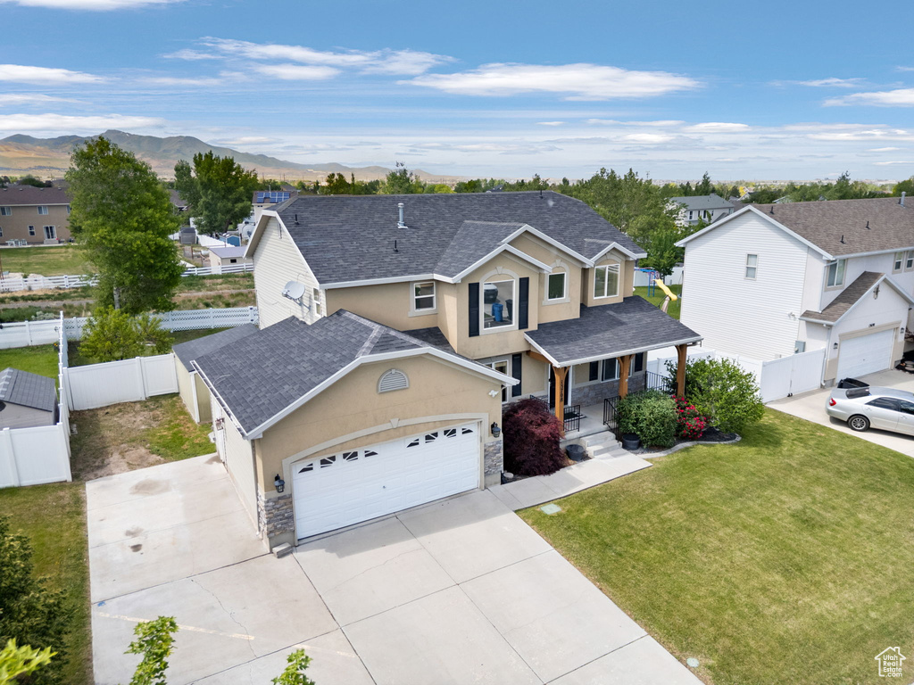 Traditional home with stone siding, a residential view, stucco siding, and driveway