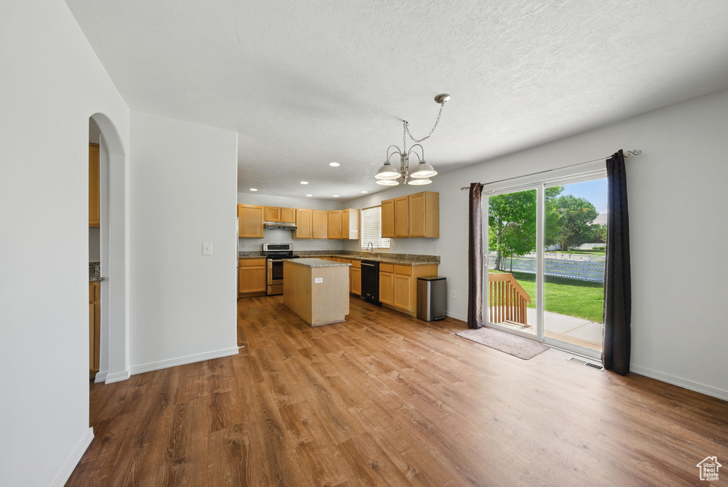 Kitchen with stainless steel range oven, dishwasher, light wood-type flooring, arched walkways, and a chandelier