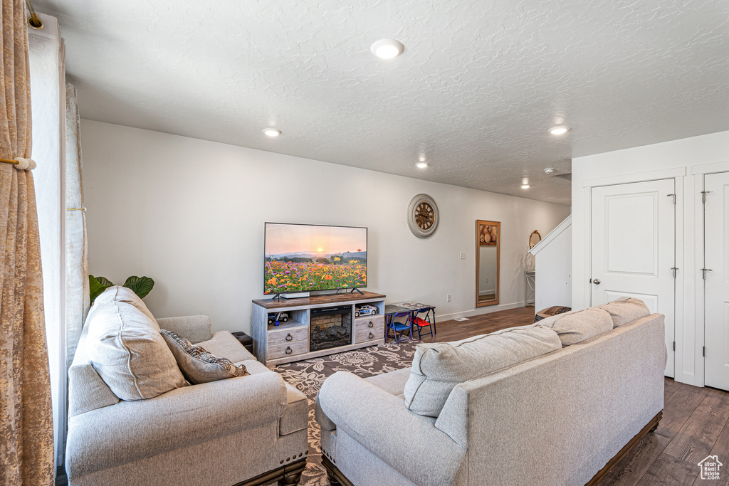 Living area featuring dark wood finished floors, recessed lighting, and baseboards