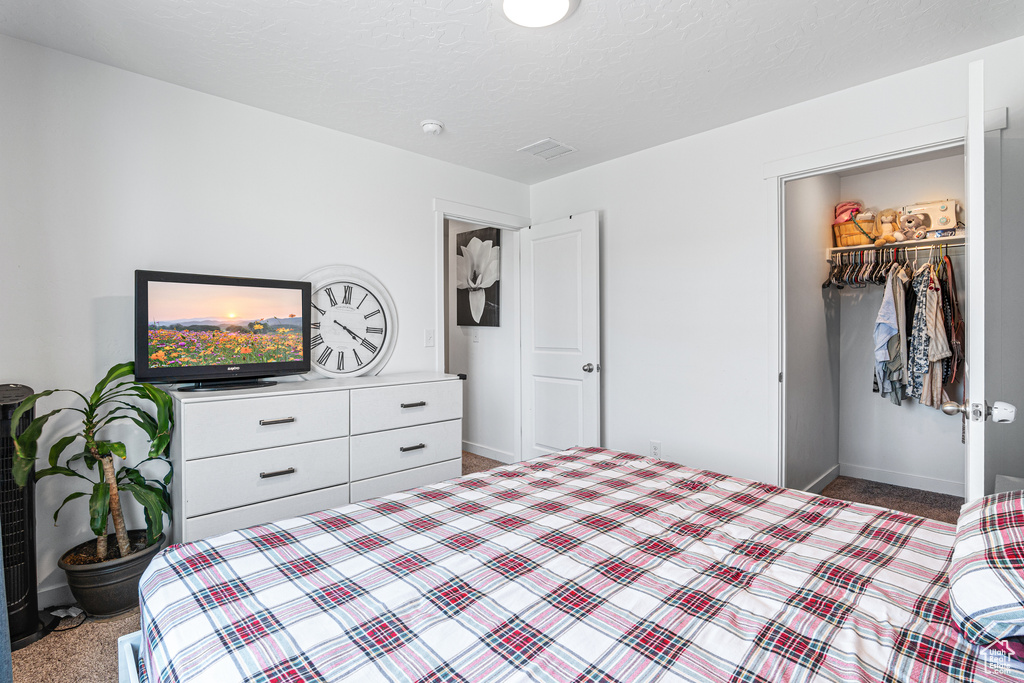 Carpeted bedroom with baseboards and a closet