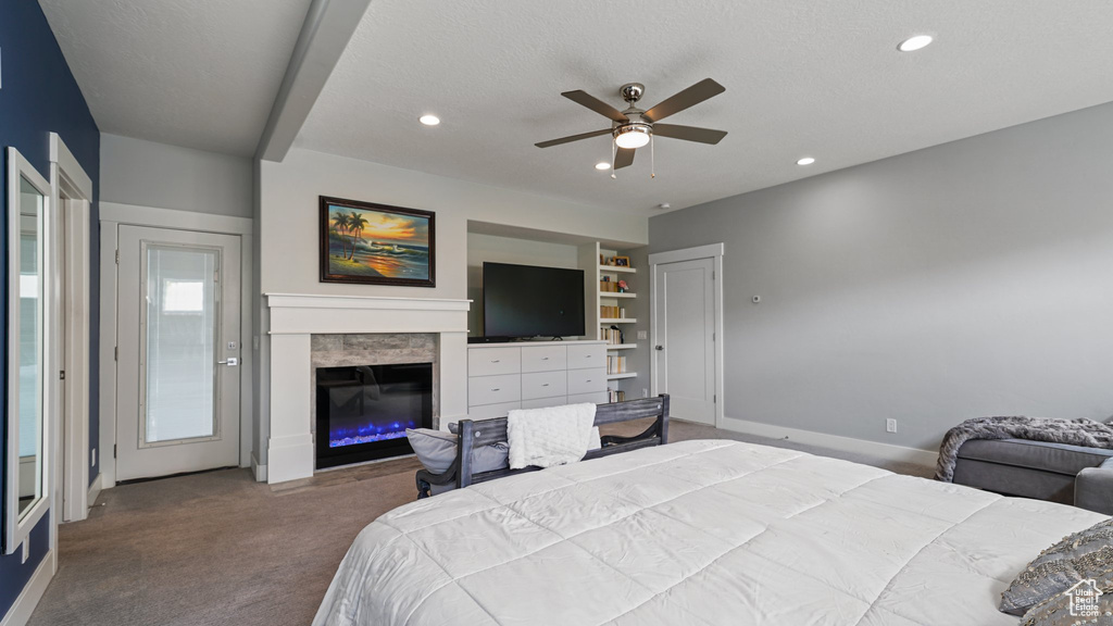 Carpeted bedroom with recessed lighting, a glass covered fireplace, baseboards, and ceiling fan