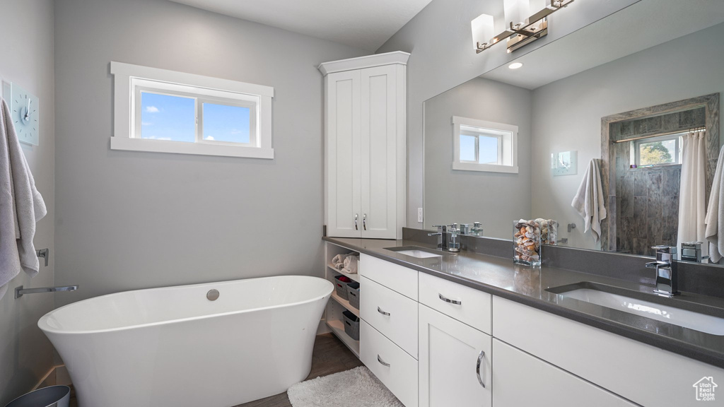 Bathroom featuring double vanity and a freestanding tub