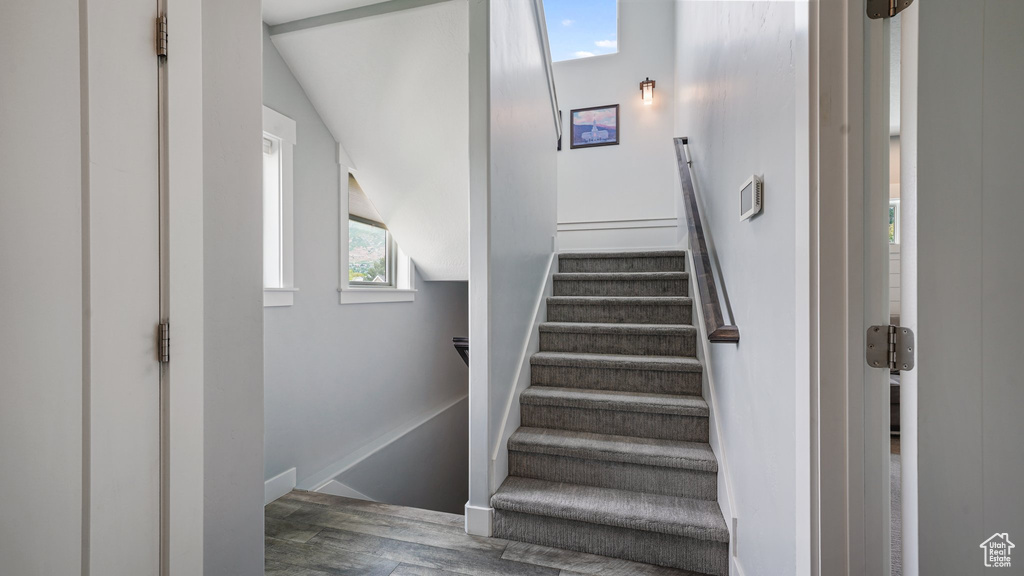 Stairs featuring wood finished floors and baseboards