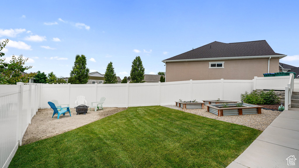 View of yard with an outdoor fire pit and a vegetable garden