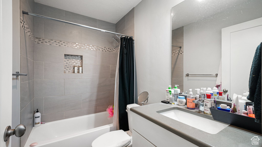 Full bathroom with vanity, shower / bath combination with curtain, and toilet