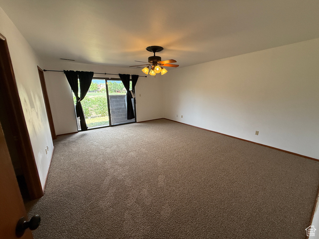 Unfurnished room featuring ceiling fan, light carpet, and baseboards