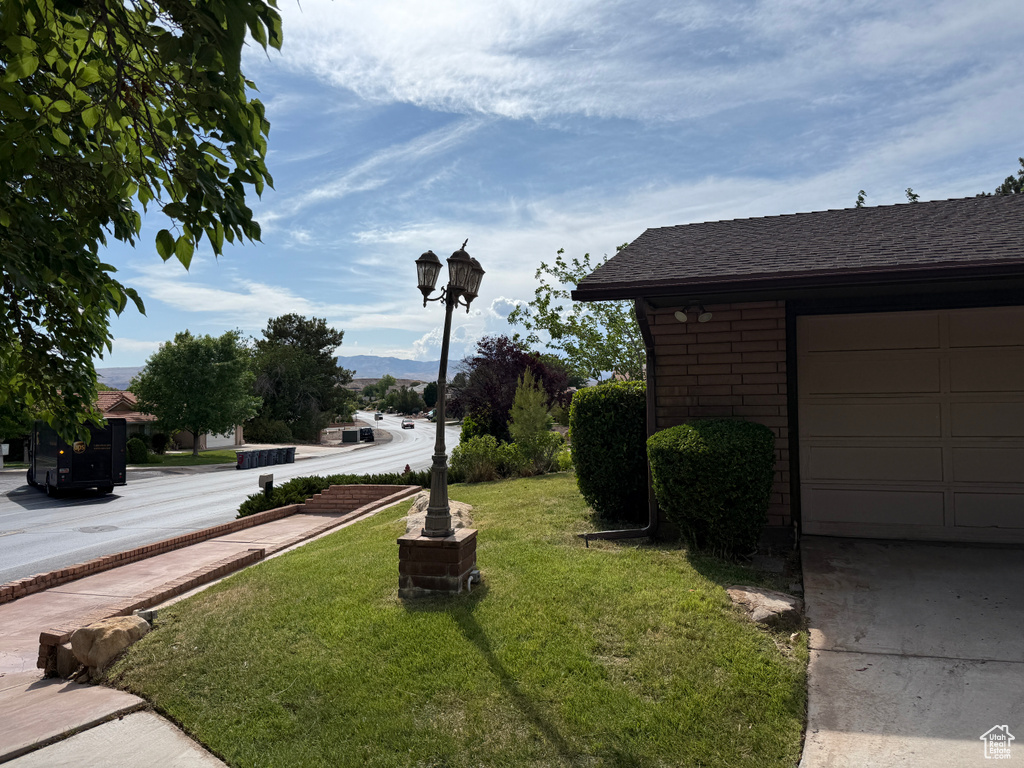 View of green lawn with a garage