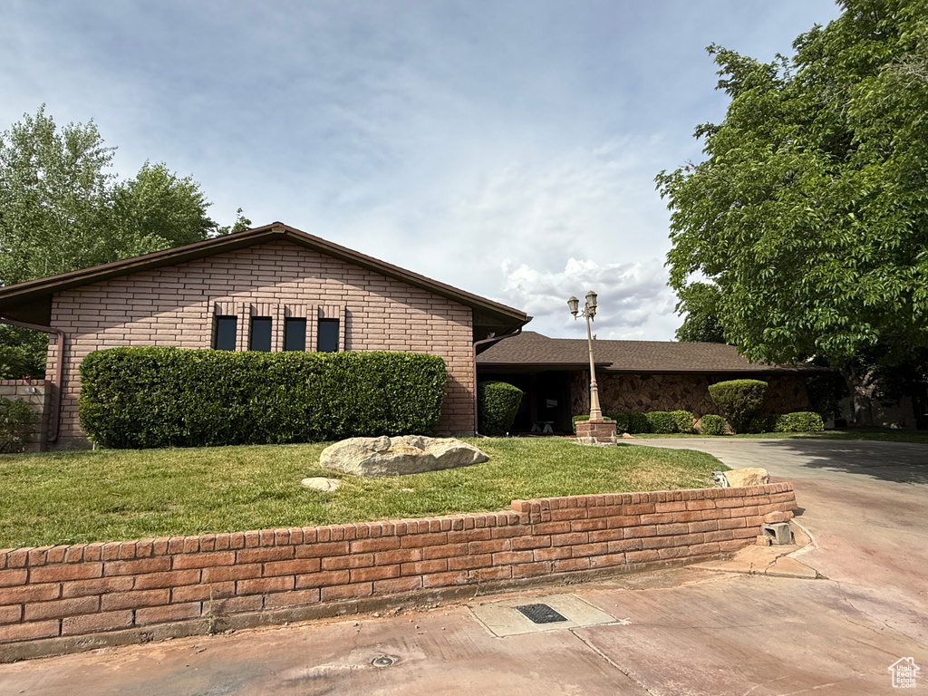 View of front of home with a front yard and driveway