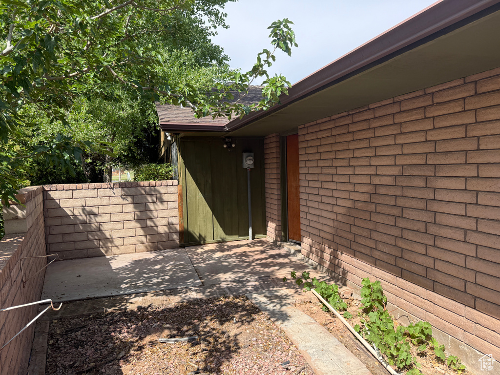 Property entrance featuring a patio and brick siding