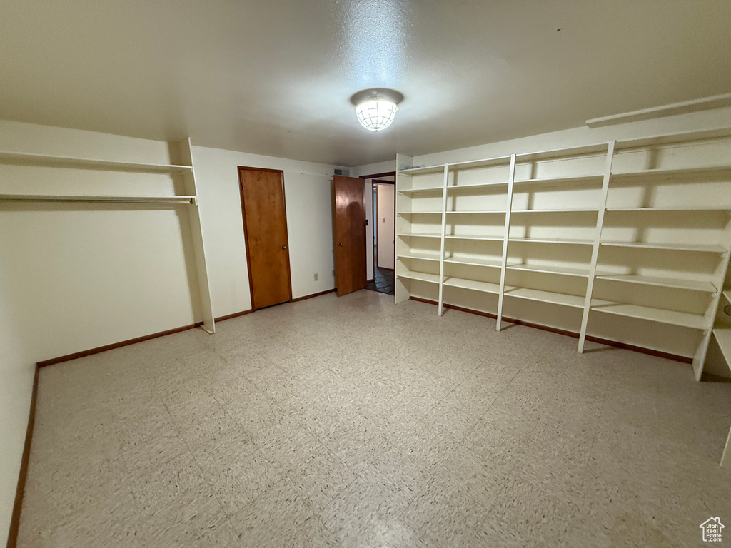 Unfurnished bedroom with light floors, multiple closets, and baseboards