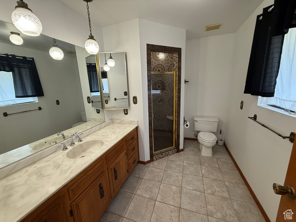 Bathroom featuring toilet, vanity, a shower stall, and baseboards