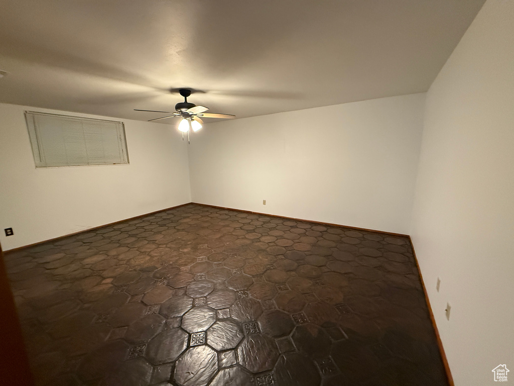 Spare room featuring ceiling fan and baseboards