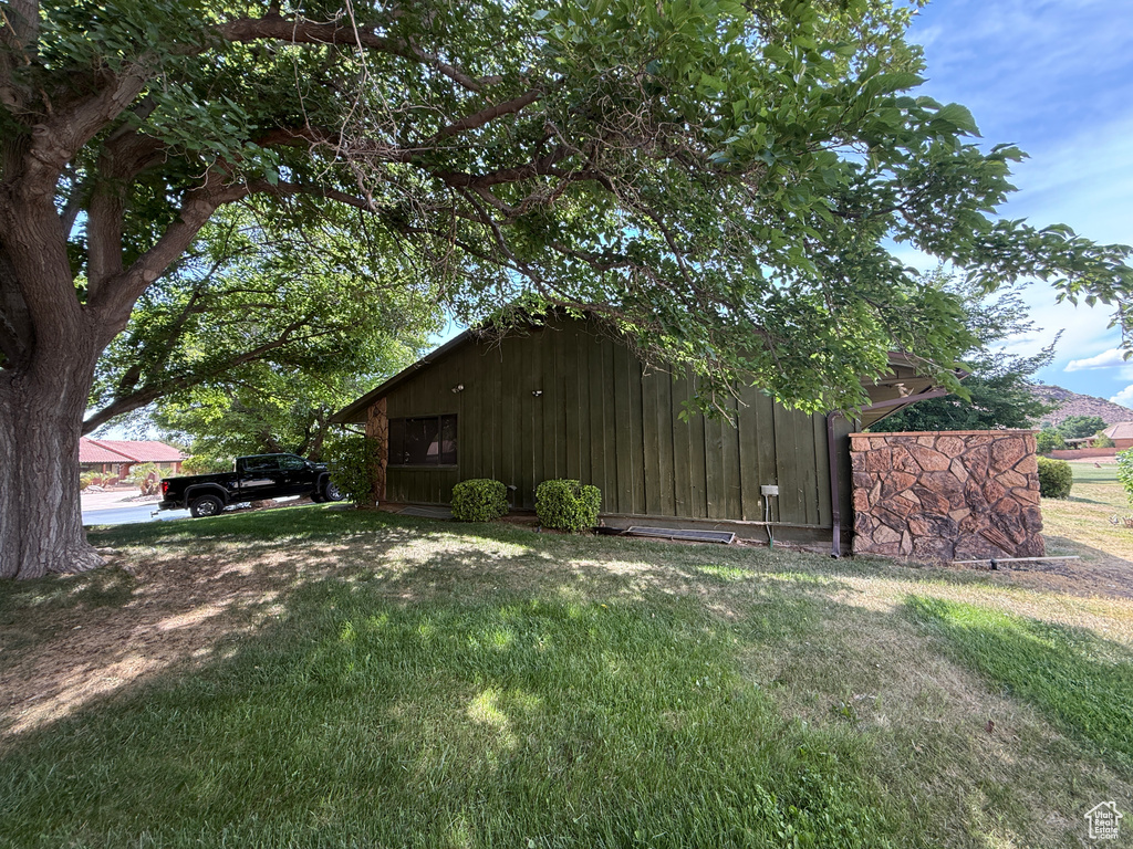 View of side of home featuring a yard