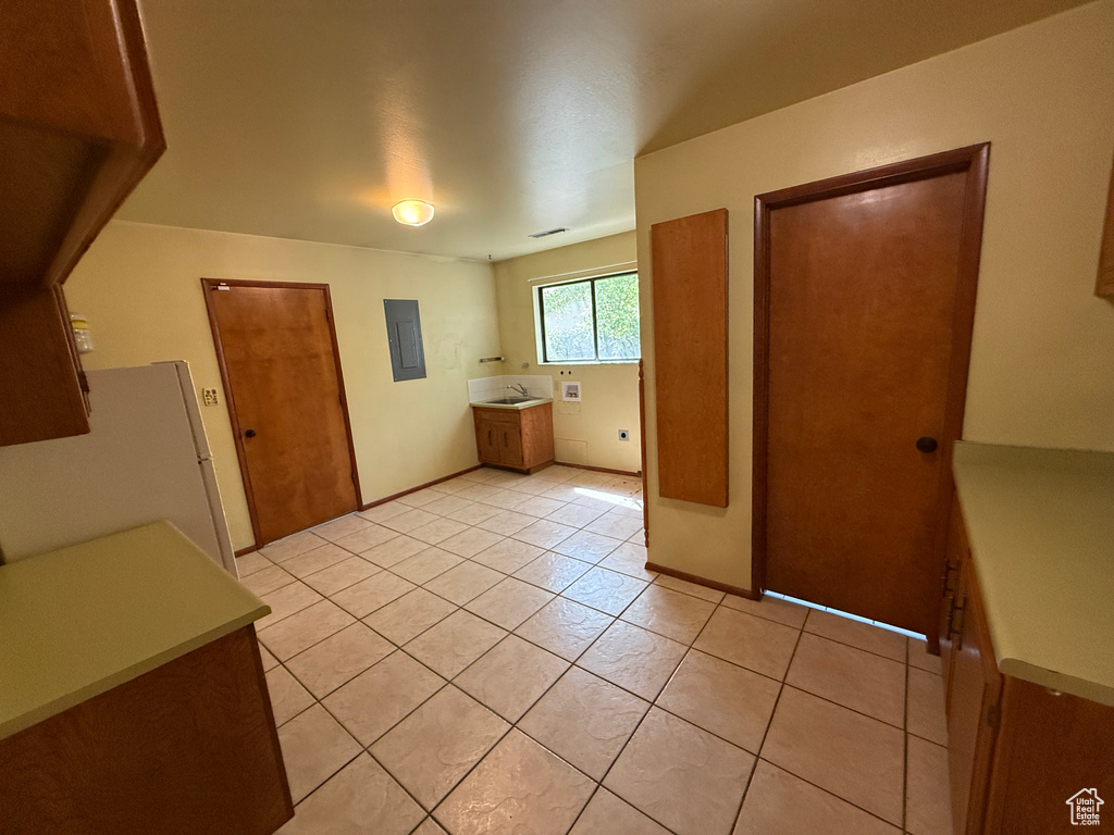 Interior space featuring light tile patterned flooring, washer hookup, and baseboards