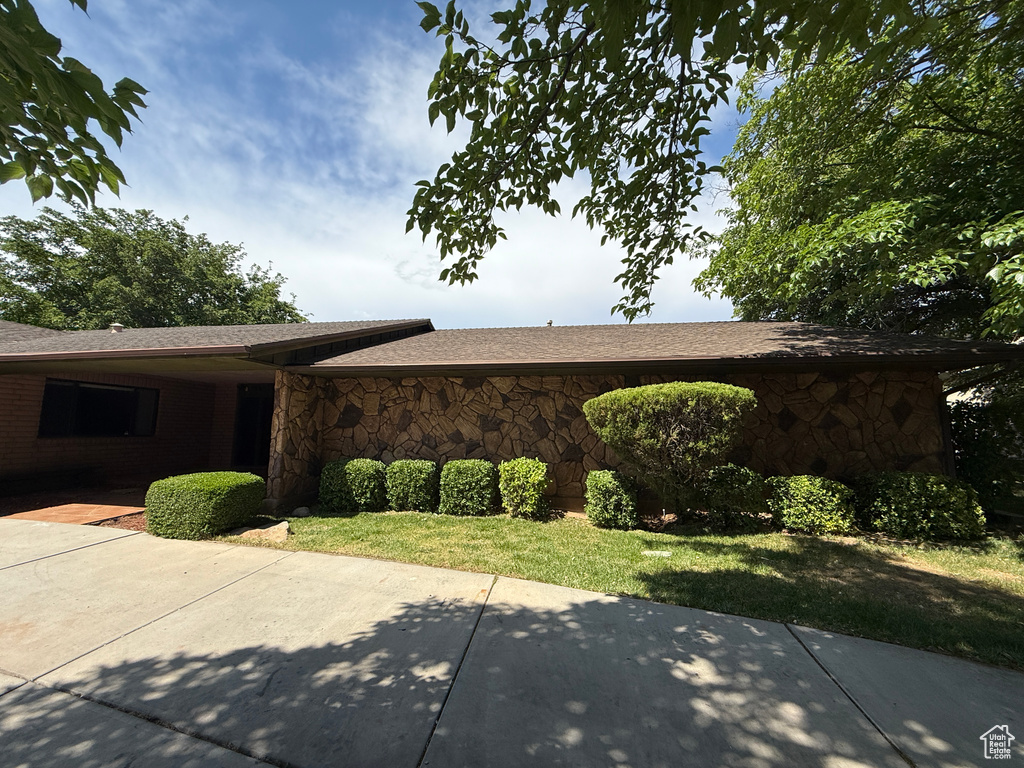 View of home\'s exterior with stone siding and a patio area