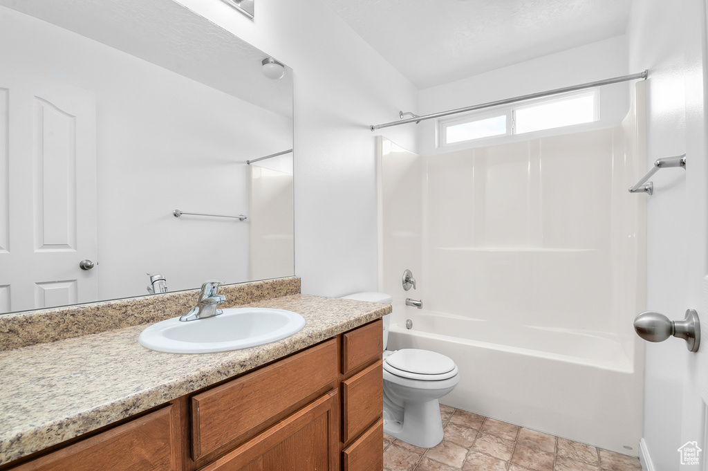 Full bath featuring vanity, shower / bathtub combination, toilet, and stone finish floors