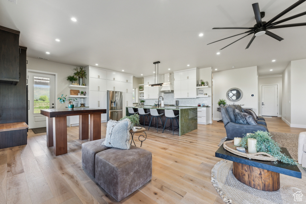 Living room featuring ceiling fan, light wood-style flooring, and recessed lighting