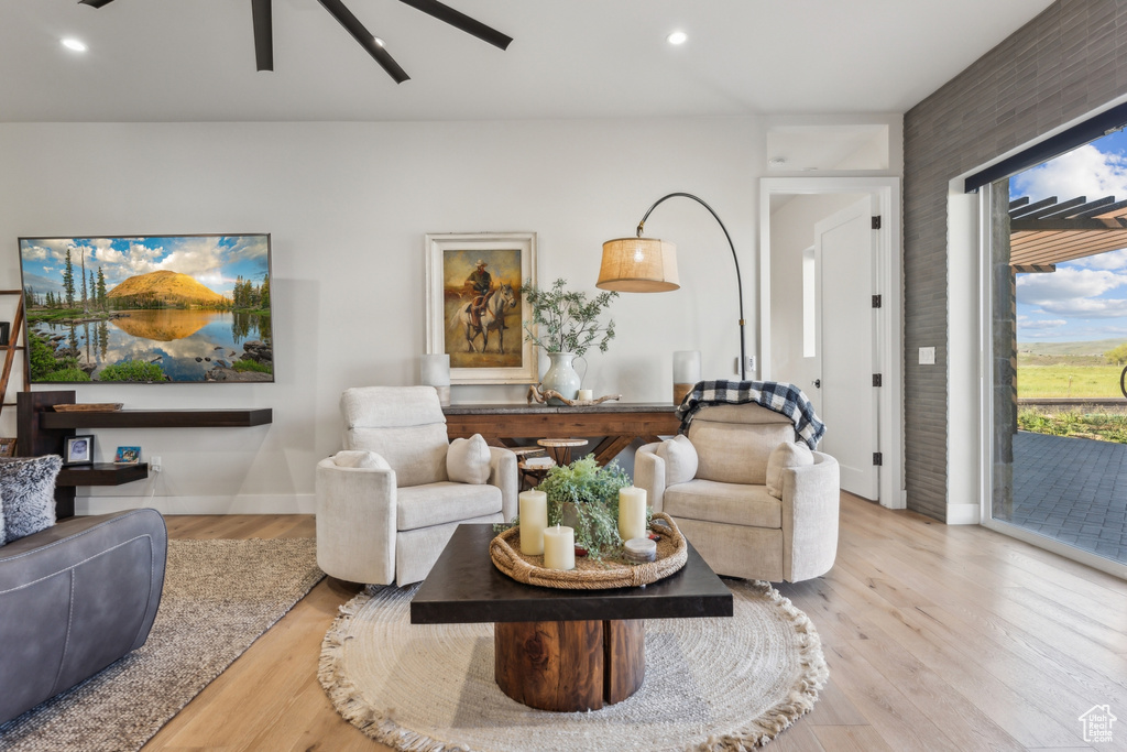 Living area with light wood-style floors, ceiling fan, baseboards, and recessed lighting