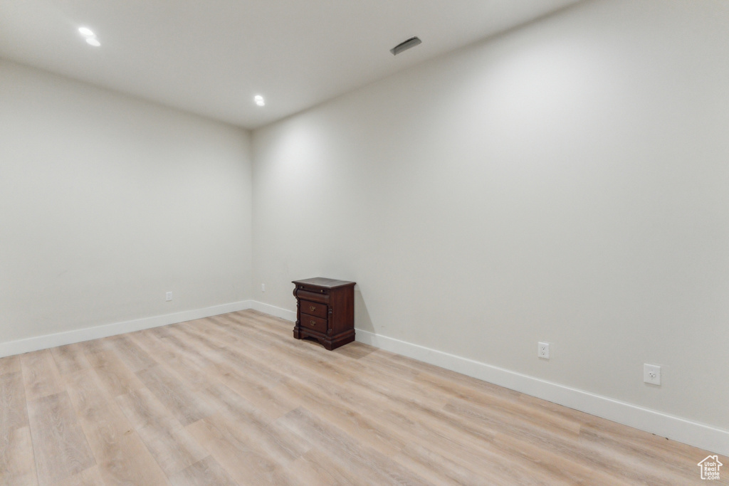 Spare room with light wood finished floors, baseboards, and recessed lighting