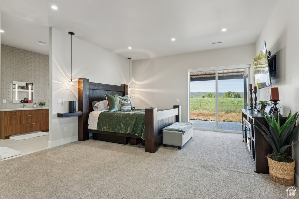 Bedroom with access to outside, light carpet, recessed lighting, and connected bathroom