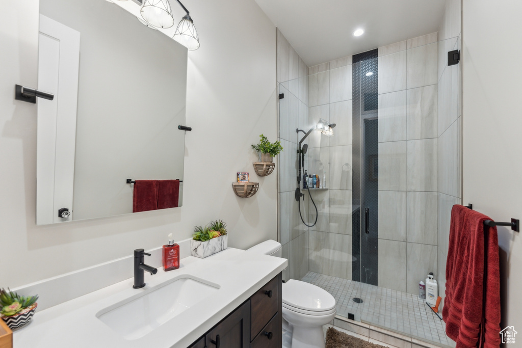 Bathroom with vanity, toilet, a stall shower, and recessed lighting