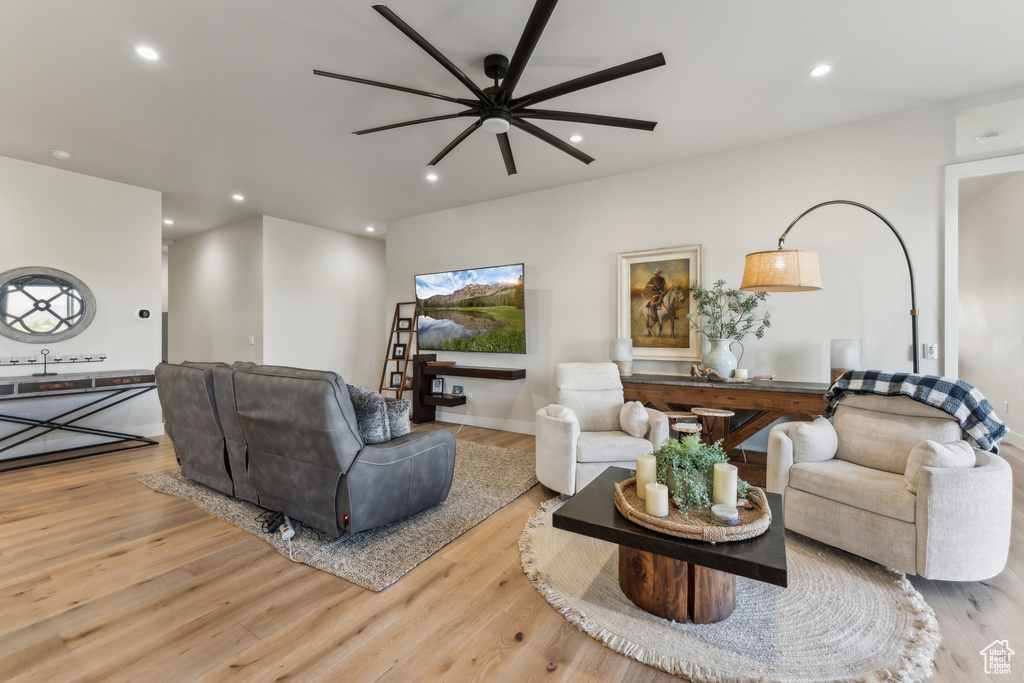 Living room with a ceiling fan, recessed lighting, and wood finished floors