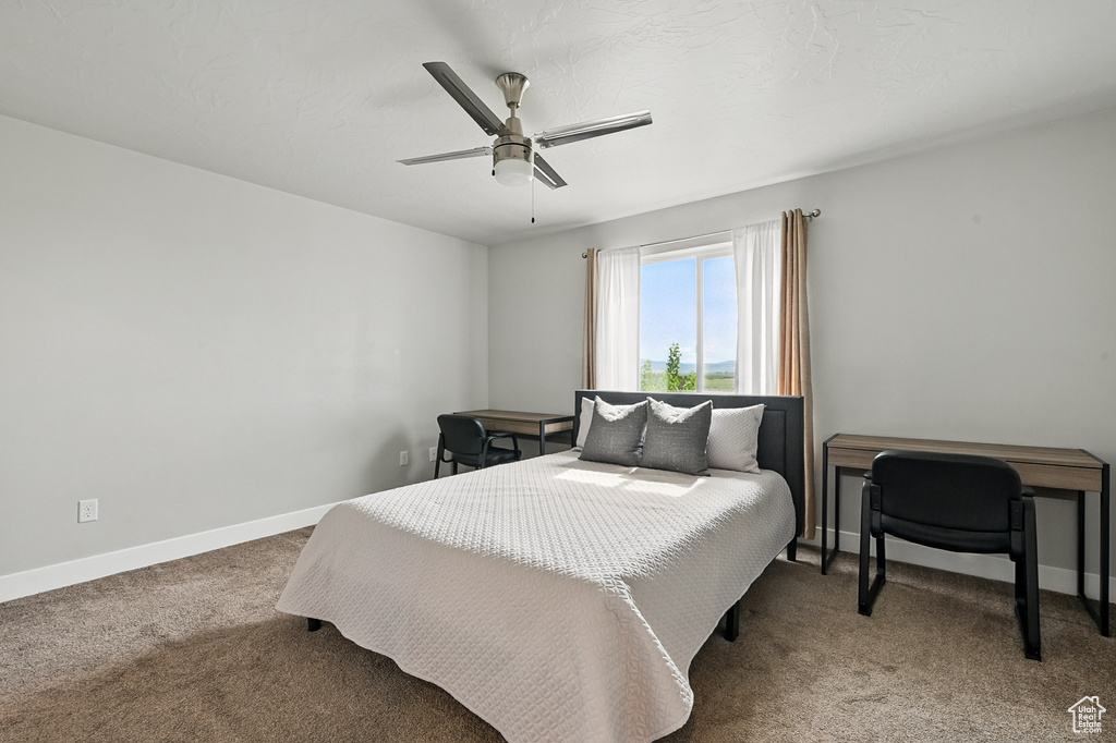 Carpeted bedroom with baseboards and ceiling fan