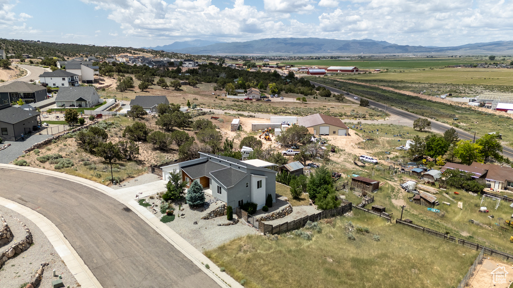 Aerial view of property and surrounding area with mountains and nearby suburban area