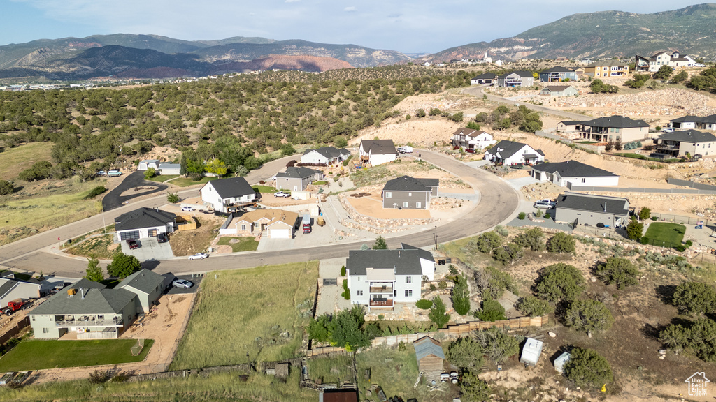 Aerial view of property and surrounding area featuring a mountainous background and nearby suburban area