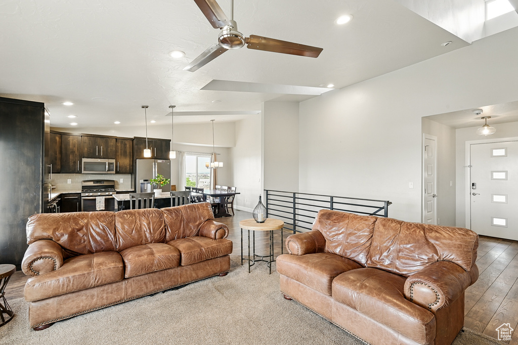 Living room with recessed lighting, a ceiling fan, a chandelier, and baseboards