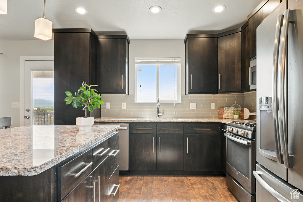 Kitchen featuring appliances with stainless steel finishes, a sink, healthy amount of natural light, light wood-type flooring, and recessed lighting